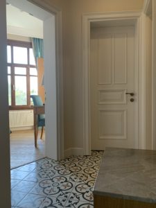 タイル床玄関と白木戸・真鍮色ドアノブ